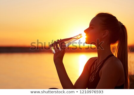 Stock fotó: Woman Drinking Water After Training Silhouettes