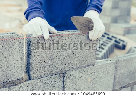 商業照片: Bricklayer Worker Installing Brick Masonry On Exterior Wall With