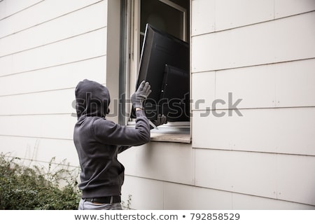 Stock foto: Robbers Stealing Television Through House Window