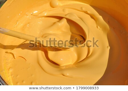 [[stock_photo]]: Hand Mixing Yellow Wall Paint In Bucket