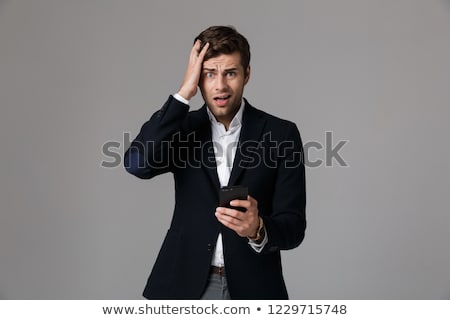 Stock photo: Image Of Stressful Man 30s In Business Suit Using Black Smartpho