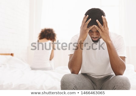 Сток-фото: Upset African Man Sitting On Bed