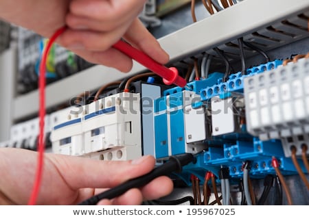 Foto stock: Male Electrician Examining Fuse Box With Multimeter
