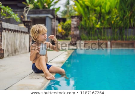 Stockfoto: The Boy Eats Chia Pudding In The Morning By The Pool Healthy Breakfast Useful Food For Children