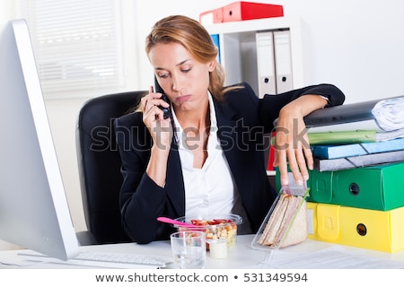 ストックフォト: Exceeded Businesswoman Sitting On Her Desk