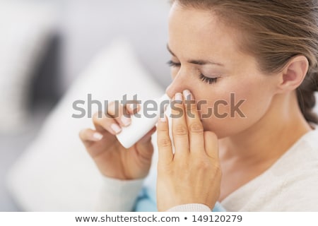 Foto stock: Beautiful Young Woman Spraying Nose