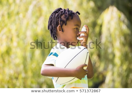 Foto stock: A Black Boy Using An Asthma Inhaler