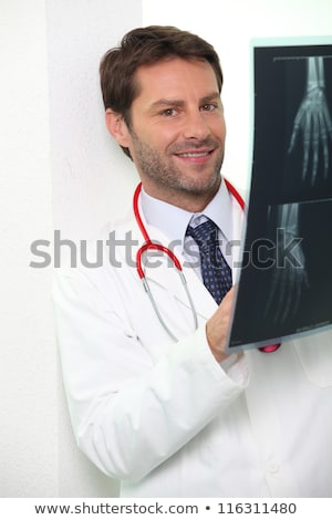 Foto stock: Hospital Doctor Examining An X Ray Of Someones Hand