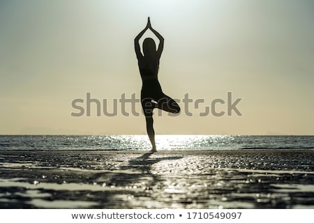 Foto stock: Active Woman Practicing Yoga On The Beach