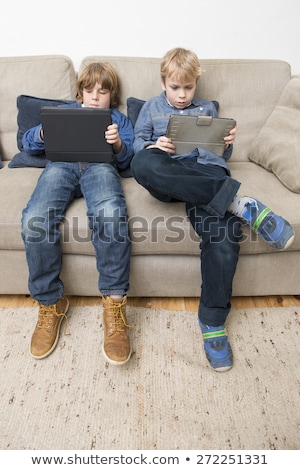 Foto stock: Two Boys Playing Video Games On A Tablet Computer