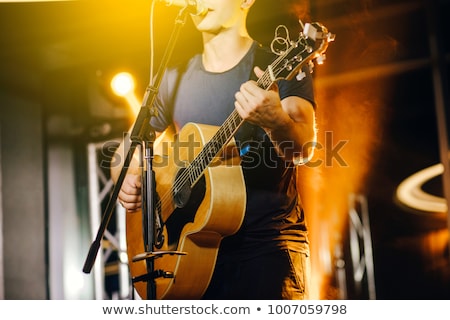 Zdjęcia stock: Singing And Playing Acoustic Guitar On Stage