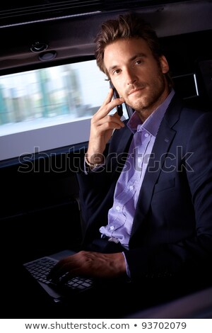 Stockfoto: Serious Young Executive On Phone In Limousine