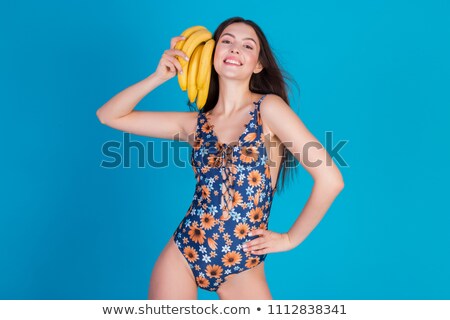 Stok fotoğraf: Pretty Young Woman In Swimsuit Posing And Holding Banana