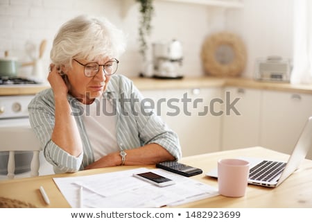 Foto stock: Senior Woman With Papers And Calculator At Home