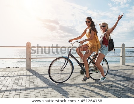 Foto d'archivio: Two Young Beautiful Women Friends Outdoors With Bicycles