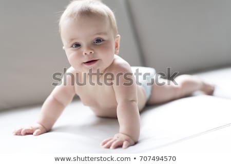 Stockfoto: Baby Boy In Diapers Sitting On Sofa At Living Room