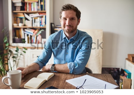 商業照片: Portrait Of Young Man Sitting Indoors At His Office And Working