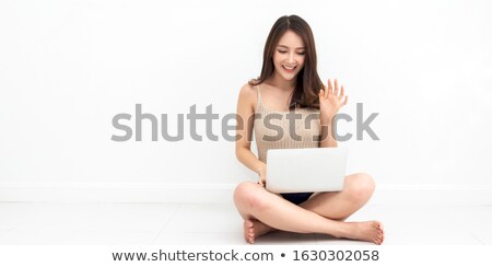 Stockfoto: Portrait Of A Smiling Asian Businesswoman Looking At The Camera Sitting Against White Background