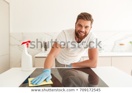 Stock fotó: Casual Bearded Man Wipes A Stove