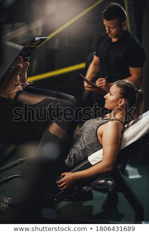 Stockfoto: Fitness Woman Exercising Her Legs On Machine