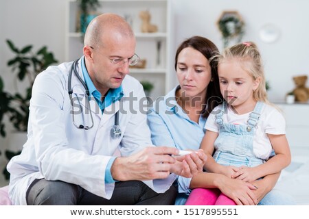 Stockfoto: Confident Doctor Showing Temperature Of Sick Little Patient On Thermometer