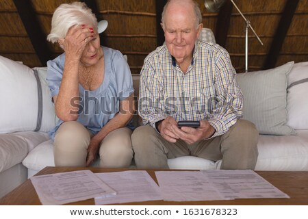 Stock fotó: Front View Of A Worried Senior Couple Discussing Over Medical Bills And Calculating In Living Room A