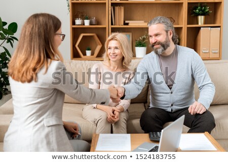 Zdjęcia stock: Happy Mature Bearded Man Giving Hand To Young Real Estate Advisor