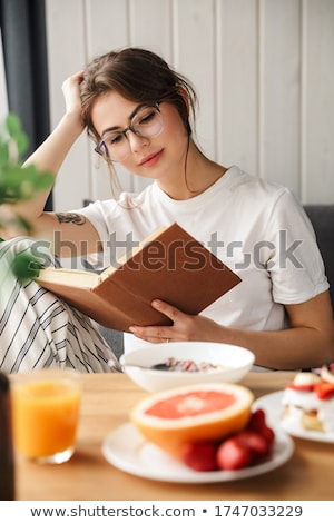 Stock foto: Photo Of Beautiful Focused Woman Reading Book While Having Breakfast