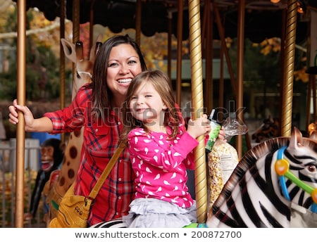 Foto stock: Mother And Daughter On Carousel