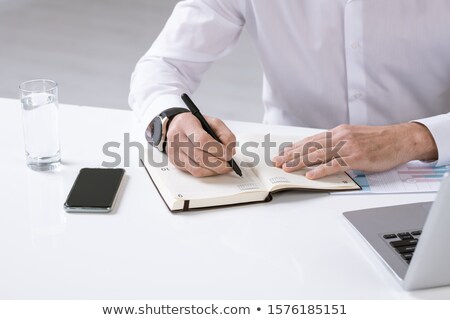 Сток-фото: Hands Of Employer With Pen Over Page Of Notebook Writing Down Plan For The Day