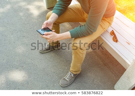 ストックフォト: Portrait Of A Handsome Young Man Sitting In The Sun On Bench At