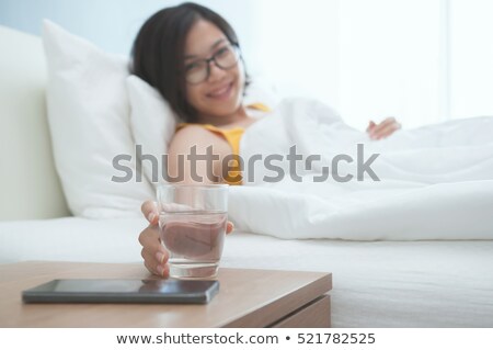 ストックフォト: Glass Of Water And Phone In Bed