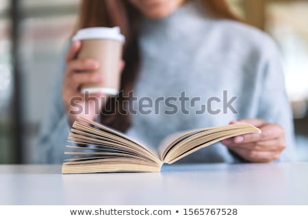 Stok fotoğraf: Girl Reading A Book While Sitting At Table