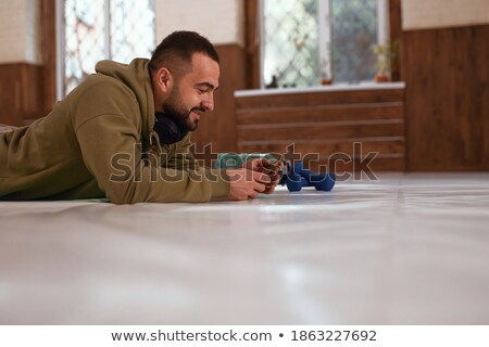 Stock photo: Handsome Young Strong Sportsman In Gym Lies On Floor