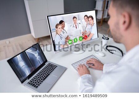 Zdjęcia stock: Doctor Examining Knee X Ray On Laptop