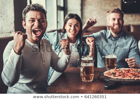 Stock fotó: Fans Of A Sports Team Watching Game In Bar