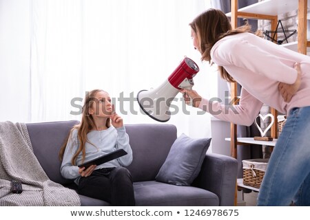 Stok fotoğraf: Mother Shouting Through Megaphone At Girl Using Digital Tablet