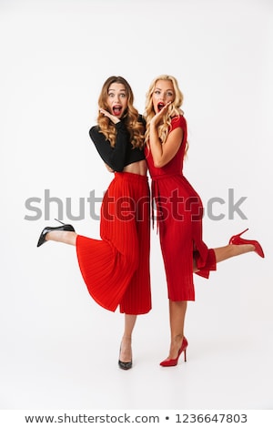 Stock foto: Happy Young Two Girls Friends Posing Isolated Over White Wall Dressed In Black And Red Clothes