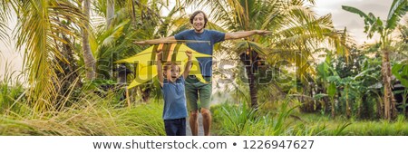 Foto d'archivio: Dad And Son Launch A Kite In A Rice Field In Ubud Bali Island