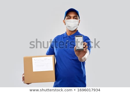 Stok fotoğraf: Indian Delivery Man With Smartphone And Parcel Box