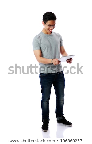 Stock photo: Full Length Portrait Of A Happy Asian Man Using Tablet Computer Over White Background