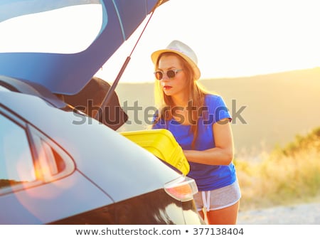 Foto stock: Young Woman Loading Luggage Into The Back Of Car