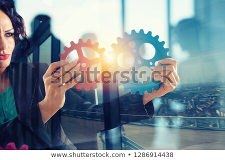 Stockfoto: Businesswoman Tries To Connect Gears Pieces Concept Of Teamwork Partnership And Integration Doubl