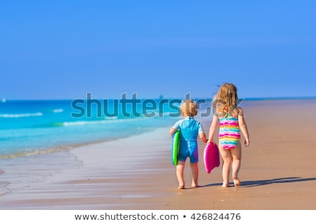 Stockfoto: Little Girls With Surfing Boards Playing On Tropical Ocean Beach