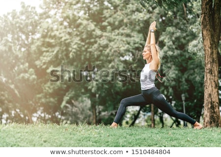 Stock foto: Woman Doing Yoga Asana Virabhadrasana 1 - Warrior Pose Outdoors