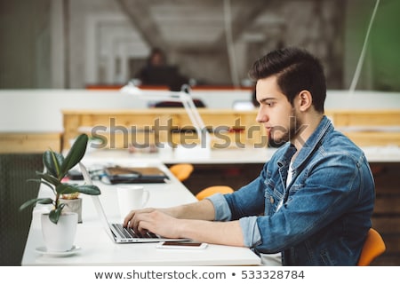 Foto d'archivio: Attractive Young Man Working With A Laptop At His Office He Is