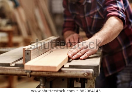 Foto stock: Man Sawing Plank Of Wood