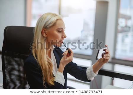 Сток-фото: Businesswoman Applying Lipstick