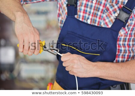 Foto d'archivio: Electrician Hands Stripping Wires