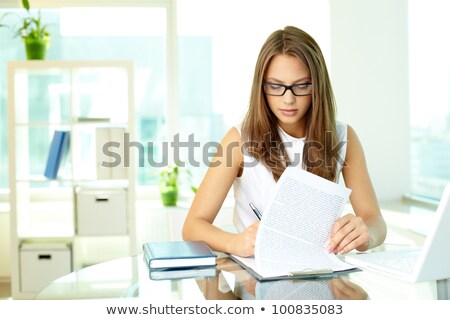 Foto d'archivio: Girl Writing On The Paper Attached To A Clipboard